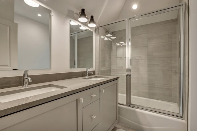 full bath with double vanity, enclosed tub / shower combo, and a sink