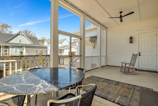 sunroom featuring a residential view and a ceiling fan