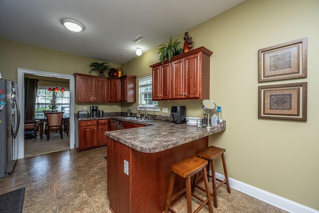 1409 Bloomingdale Ln, Mount Pleasant, SC 29466 - kitchen featuring fridge with ice dispenser, a peninsula, a sink, dark countertops, and plenty of natural light