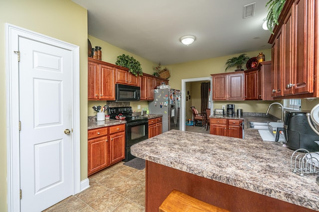 1409 Bloomingdale Ln, Mount Pleasant, SC 29466 - kitchen featuring black appliances, a sink, a peninsula, light tile patterned flooring, and light countertops