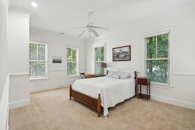 carpeted bedroom featuring crown molding, ceiling fan, and multiple windows