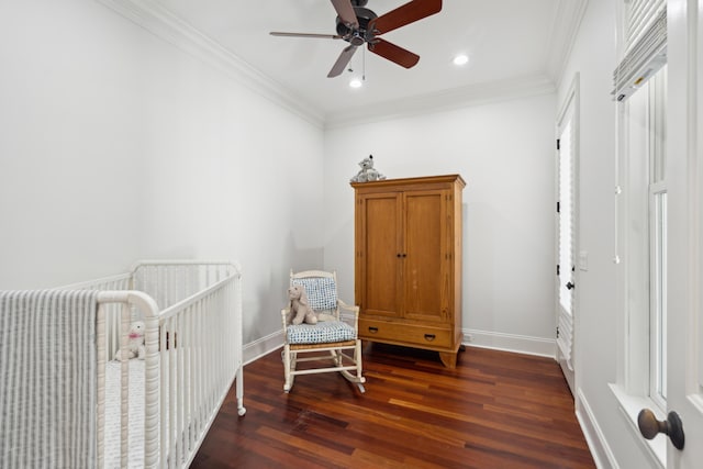 bedroom with ceiling fan, ornamental molding, dark hardwood / wood-style floors, and a crib