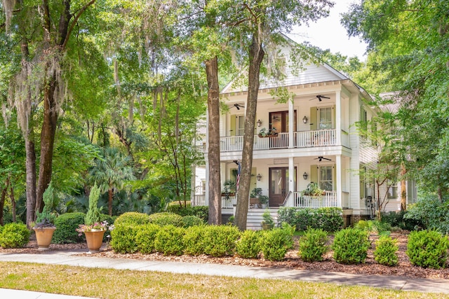 view of front of home with a balcony, ceiling fan, and covered porch