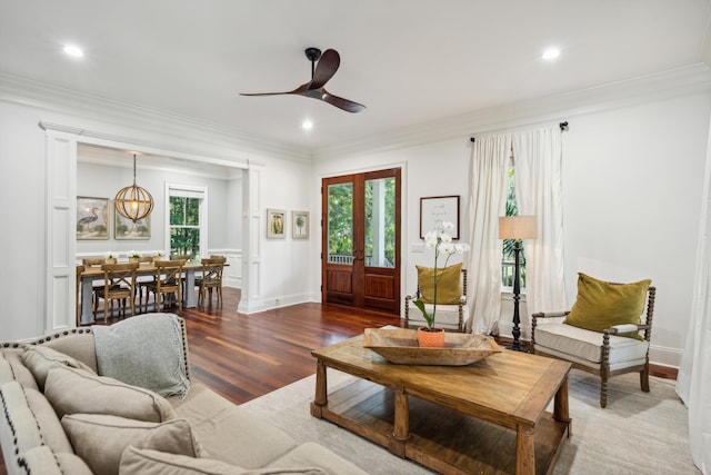 living room with crown molding, wood-type flooring, and ceiling fan