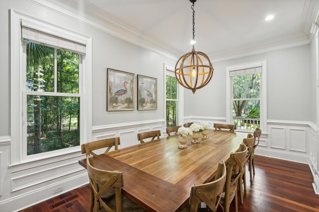 dining area with a notable chandelier, ornamental molding, and dark hardwood / wood-style floors