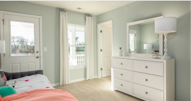 bedroom with baseboards, multiple windows, visible vents, and light colored carpet