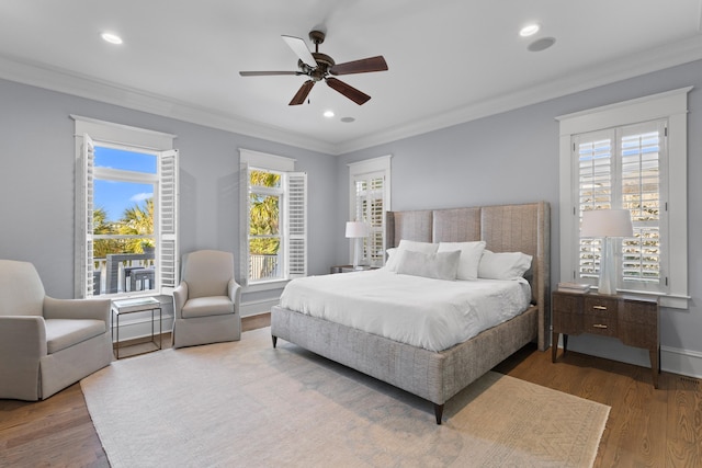 bedroom with ornamental molding, multiple windows, wood finished floors, and recessed lighting