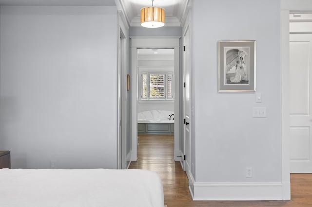 bedroom featuring crown molding, baseboards, and wood finished floors