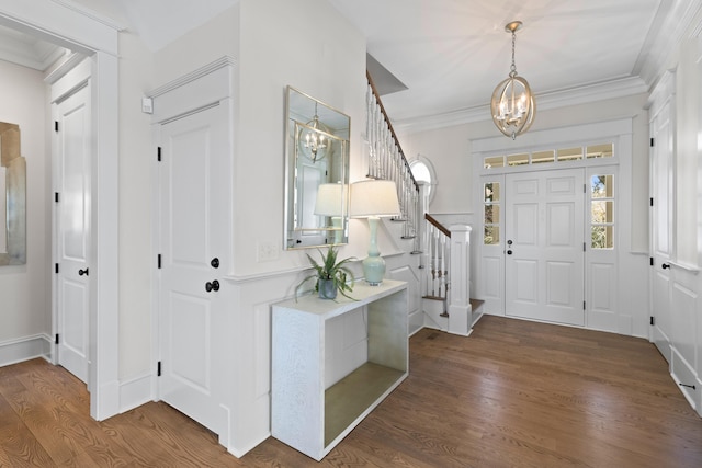 foyer featuring a notable chandelier, stairway, ornamental molding, a healthy amount of sunlight, and wood finished floors