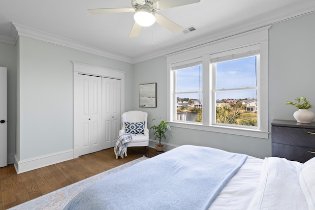 bedroom featuring ornamental molding, visible vents, baseboards, and wood finished floors