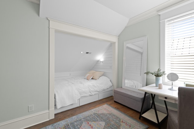 bedroom featuring crown molding, visible vents, vaulted ceiling, and wood finished floors