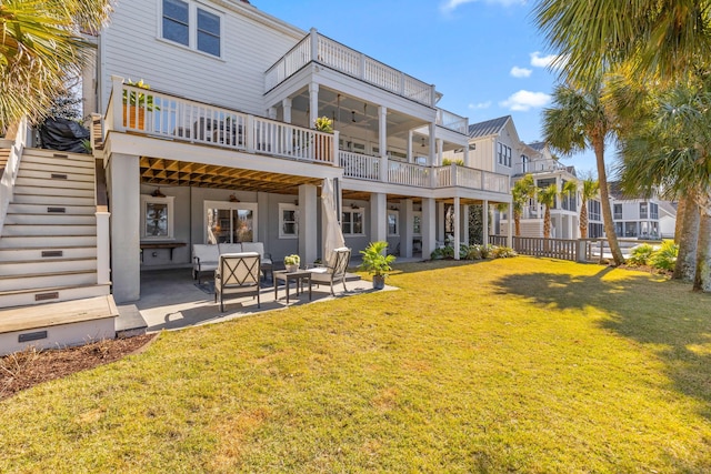 rear view of property featuring a yard, stairway, and a patio area