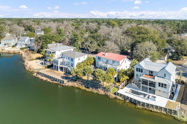 drone / aerial view featuring a forest view, a water view, and a residential view