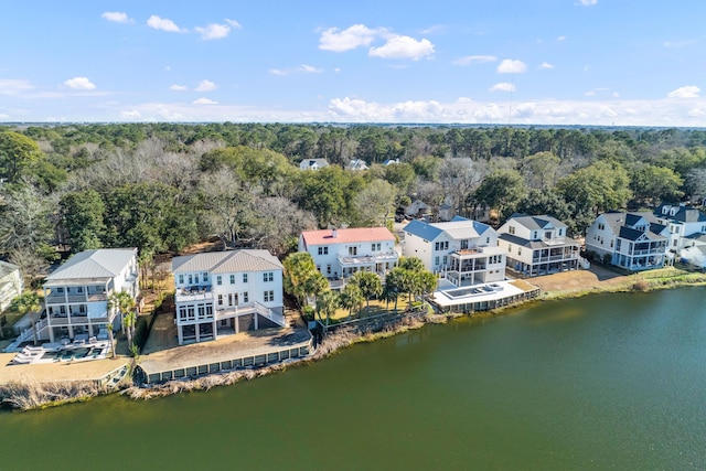 drone / aerial view with a water view, a residential view, and a view of trees