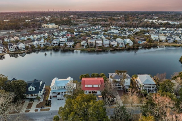 aerial view at dusk with a residential view and a water view