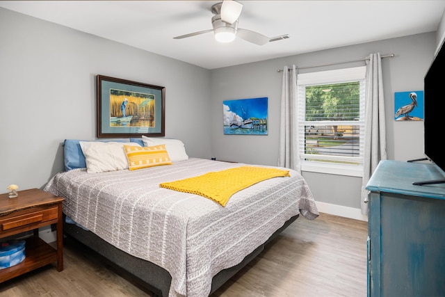 bedroom with wood finished floors, a ceiling fan, and baseboards