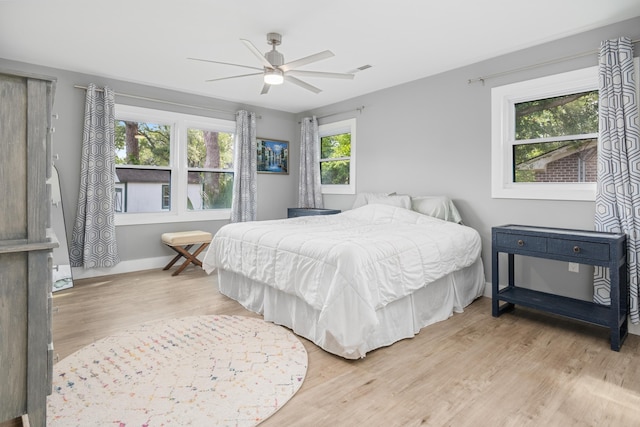 bedroom with light wood-type flooring, baseboards, and ceiling fan
