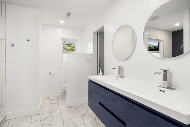 bathroom featuring toilet, baseboards, recessed lighting, and double vanity