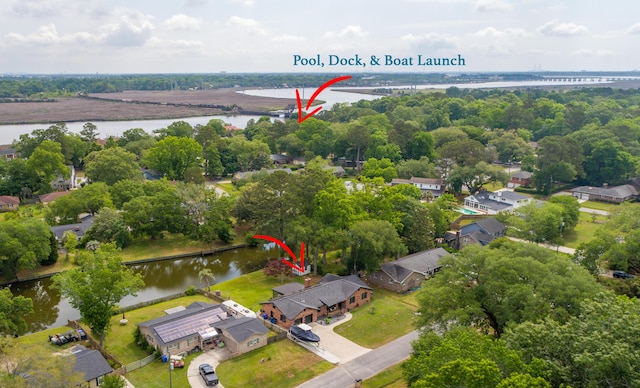 aerial perspective of suburban area with a notable bridge, a nearby body of water, and a tree filled landscape