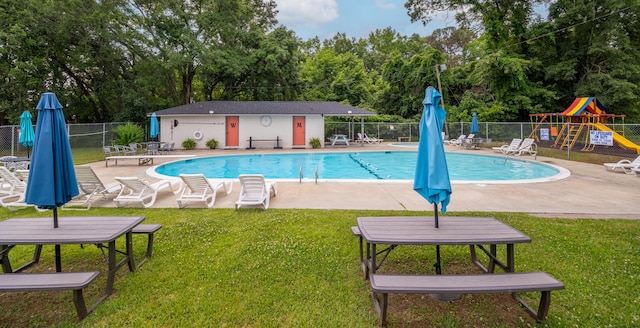 community pool with a patio and view of wooded area