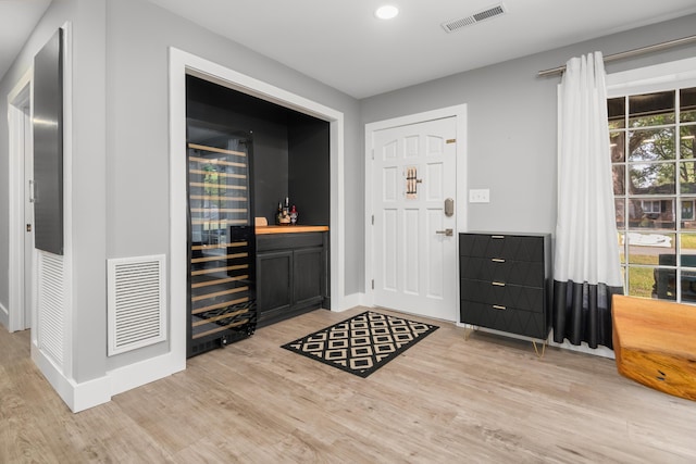 entryway with a bar, light wood-style floors, baseboards, and recessed lighting