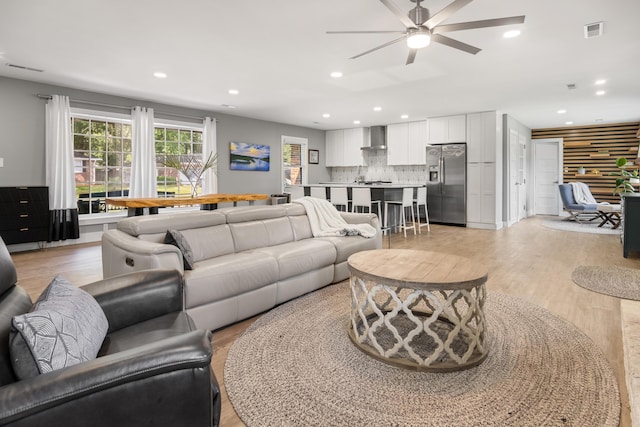 living room with ceiling fan, light wood-type flooring, and recessed lighting