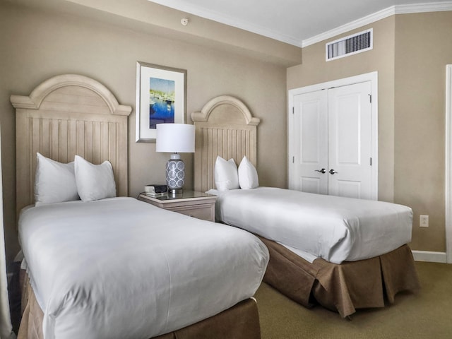 carpeted bedroom featuring a closet, visible vents, crown molding, and baseboards