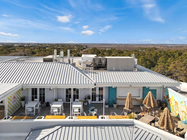 back of property with metal roof, french doors, a patio, and outdoor dining area