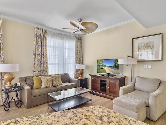 living room with a ceiling fan, crown molding, and wood finished floors