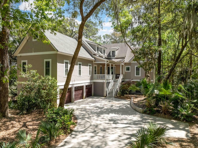 2932 Old Drake Dr, Seabrook Island, SC 29455 - view of front of property featuring driveway, covered porch, a garage, a shingled roof, and stairway