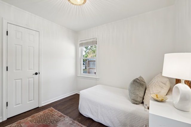 bedroom with dark hardwood / wood-style flooring and ornamental molding