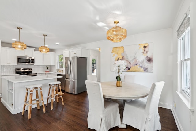 dining area featuring ornamental molding and dark hardwood / wood-style flooring