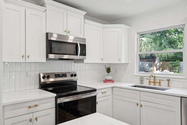 kitchen featuring white cabinetry, appliances with stainless steel finishes, sink, and decorative backsplash