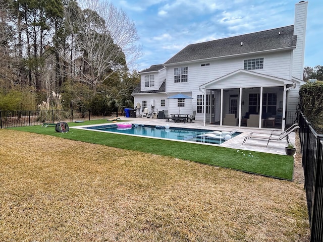 back of property with a fenced in pool, fence, a yard, a sunroom, and a patio area