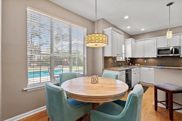 dining room featuring recessed lighting, baseboards, and light wood-style floors