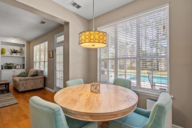 dining area with visible vents, baseboards, and wood finished floors