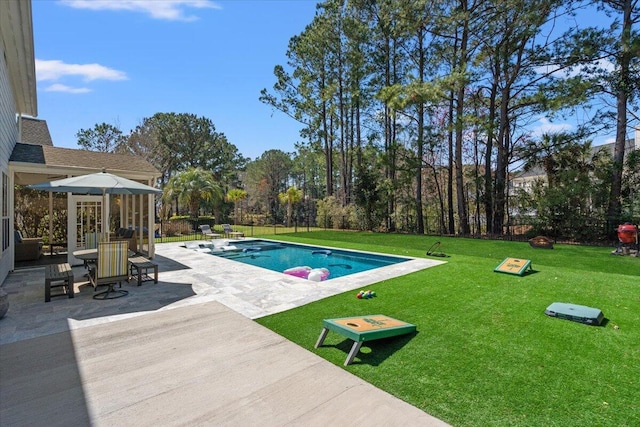 pool featuring a patio, a yard, and fence