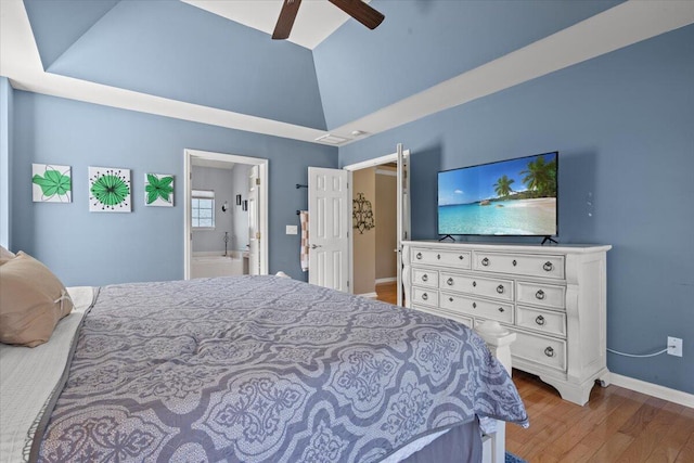 bedroom with ceiling fan, baseboards, lofted ceiling, ensuite bathroom, and wood finished floors