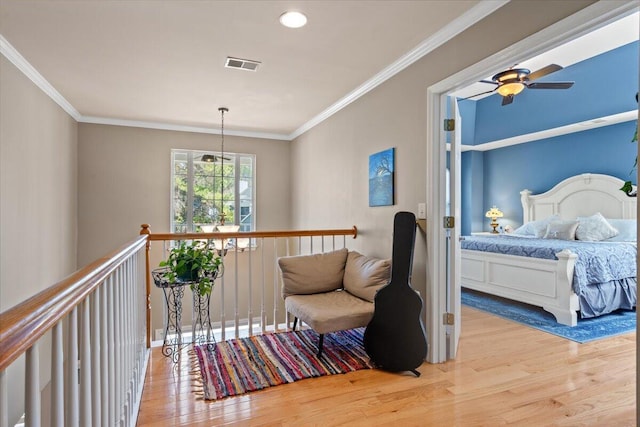 hallway featuring visible vents, wood finished floors, and crown molding