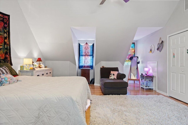 bedroom featuring vaulted ceiling, wood finished floors, baseboards, and visible vents