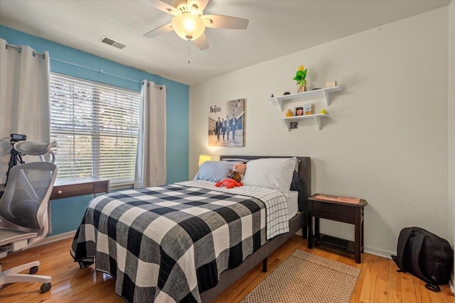 bedroom featuring visible vents, ceiling fan, baseboards, and light wood-style floors