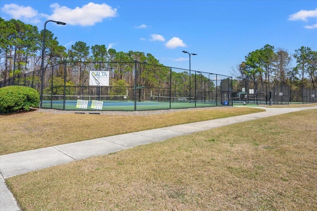 view of sport court featuring a lawn and fence