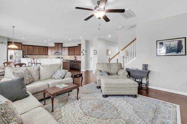 living room featuring ceiling fan and dark hardwood / wood-style flooring