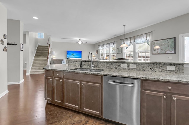 kitchen with pendant lighting, sink, stainless steel dishwasher, ceiling fan, and light stone countertops