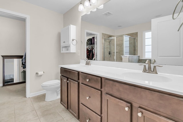 bathroom with tile patterned flooring, vanity, toilet, and walk in shower