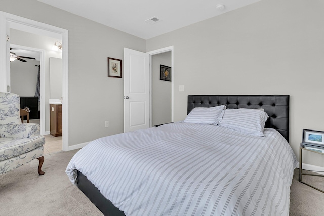 bedroom with light carpet and connected bathroom