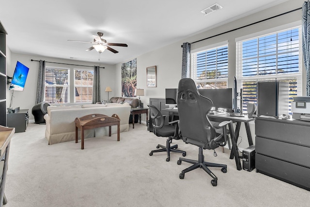 bedroom featuring multiple windows, ceiling fan, and light carpet