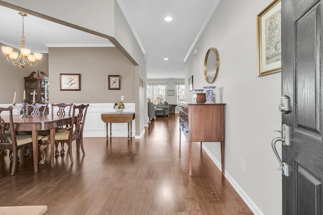 entryway featuring a notable chandelier, crown molding, and dark wood-type flooring