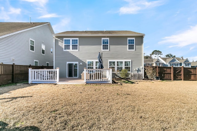 rear view of house featuring a lawn and a wooden deck