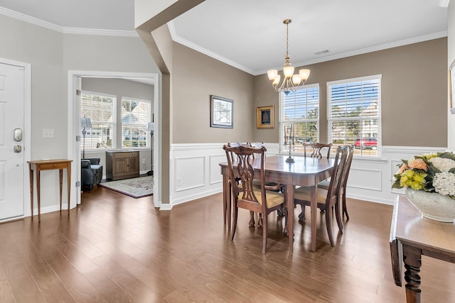 dining area with dark hardwood / wood-style floors, an inviting chandelier, and ornamental molding